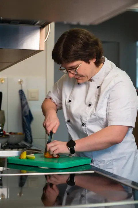 Anita Arpagaus schneidet in ihrer Küche konzentriert Obst auf einem Schneidebrett